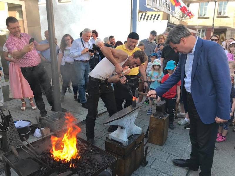 Ministerpr�sident Markus S�der schmiedet ein Kreuz aus einem einzigen St�ck Eisen.