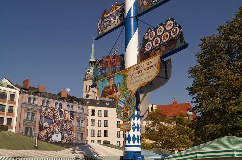 Der Maibaum auf dem Vikutalienmarkt; im Hintergrund der Turm von 